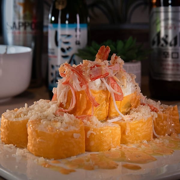 Tea Tree Asian Bistro's sushi rolls, topped with crab meat and crispy tempura flakes, drizzled with sauce.