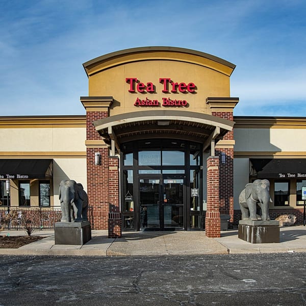 The exterior of Tea Tree Asian Bistro, featuring a brick entrance with two elephant statues.
